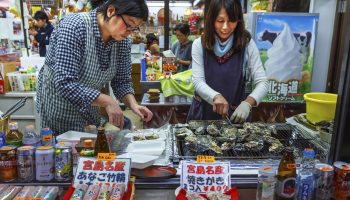 Miyajima, Japan - November 15 2013: Unidentified vendors sell grilled oyster with soy sauce to tourist which is very popular amongst the people at Omotesando Shopping Street