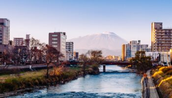 Mount Iwate Morioka city scene with buildings and promenade at Katakami river with warm sunset light