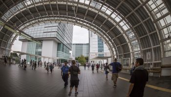 Saitama, Japan - September 20, 2014: Saitamashintoshin Station. The majority of the people walk towards the Saitama Super Arena that can be glimpsed through the windows to the right. Ahead tall office buildings rise - including the NTT DoCoMo Saitama building on the right.