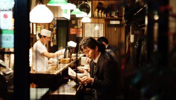 A man reading inside a small restaurant in Shinjuku, Tokyo