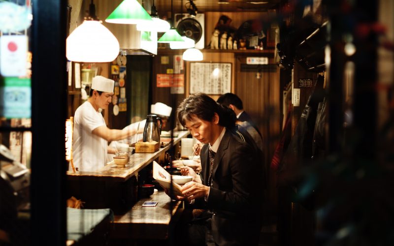 A man reading inside a small restaurant in Shinjuku, Tokyo